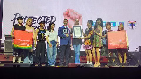 Denise van Dijk, president and chief executive officer of DKT Health Inc.; Joweeh B. Liao, director for the Health Business Unit, Finance, and Property Development at Watsons Philippines; and members of LGBTIQ+ organization UP Babaylan receive the plaque from Justin Patterson, an adjudicator from the Guinness World Records, for achieving the largest condom donation in one hour.