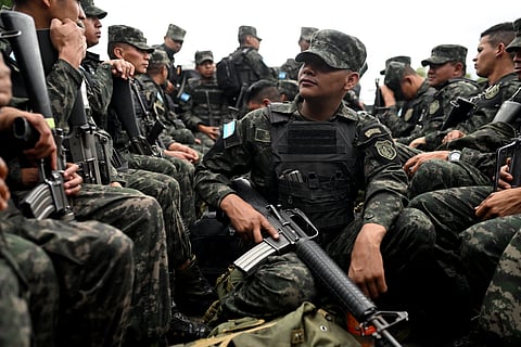Soldiers guard several trucks returning to the Electoral Logistics Center with ballots to be counted a day after the presidential elections, in Tegucigalpa.