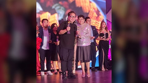 DAILY TRIBUNE's Jefferson Fernando (seen here with Glitter Gala’s Pilar Mateo) accepting the Outstanding Newspaper of the Year Award for the publication and the Seasoned Fashion and Lifestyle Editor for Dinah Ventura.