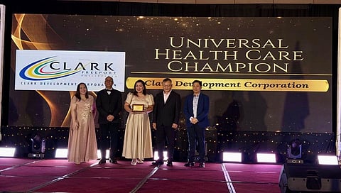 Clark Development Corporation (CDC) Health and Sanitation Division Nurse II Sarah Rucks receives the Universal Health Care Champion award on behalf of the corporation during PhilHealth’s Regional Recognition Program held on November 20 at the Kingsborough International Convention Center in the City of San Fernando, Pampanga.