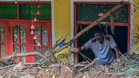 VK Muthukrishnan, 42, removes debris from his house following landslides in the aftermath of Cyclone Ditwah in Hadabima village near Sarasavigama on December 4, 2025