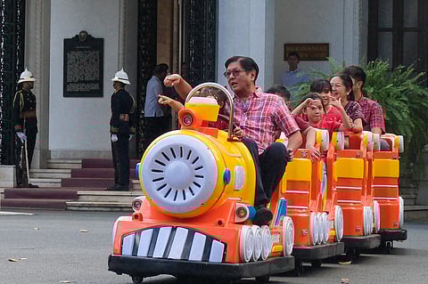 Pabitin, presents: Marcos family spreads cheer Children beamed with excitement as a traditional pabitin descended overhead during the ‘Balik Sigla, Bigay Saya 2025 Nationwide Gift-Giving,’ led by President Ferdinand R. Marcos Jr. (inset, front of train), First Lady Liza Araneta-Marcos (far end), and their son William Vincent Araneta Marcos (behind his mother) at the Kalayaan Grounds in Malacañang Palace