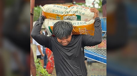 A MAN takes home a free sack of rice from volunteers of BCFI and Solaire Cares.
