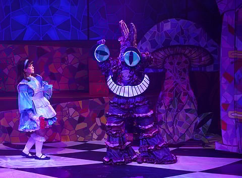 ALICE with the Cheshire Cat, a role alternated by Stephen Viñas and Sebastian Katigbak, in ‘Alice in Wonderland.’