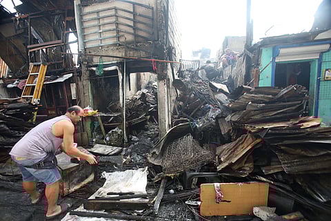 RESIDENTS of Barangay Pleasant Hills in Mandaluyong City sift through fire debris to salvage reusable materials, a day after a 5th alarm fire razed homes in the area on Friday night.
