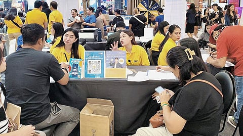 BDO employees attend to a migrant workers’ banking needs at the Pamaskong Handog 2025 event in SM City Laoag.