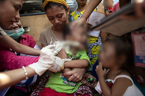 (FILES) A child reacts during a Philippine Red Cross Measles Outbreak Vaccination Response in Baseco compound, a slum area in Manila on 16 February 2019.