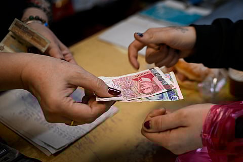 A GROCERY store owner returns lev banknotes to a customer in a grocery store in the village of Chuprene, northwestern Bulgaria on 7 December 2025.
