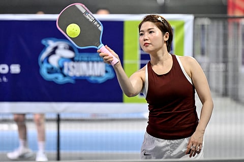A WOMAN plays pickleball in the playground of a residential area
in Hanoi.