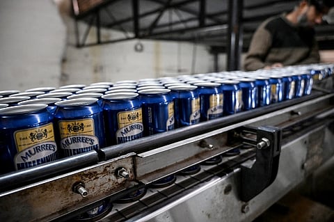 This photograph taken on December 17, 2025 shows a worker checking beer cans on a production line at Murree Brewery in Rawalpindi. A heady aroma of malt and brewing yeast drifts through Pakistan's oldest and by far largest brewery, which is gearing up for expansion after getting approval to sell abroad after a nearly 50-year ban.