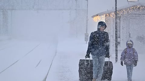 A WOMAN and child make their way with their luggage at the train station in Are as storm Johannes moves in over northern Sweden causing cancelled departures. (AFP)
