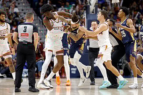 Jose Alvarado #15 of the New Orleans Pelicans gets into a scrum with Mark Williams #15 of the Phoenix Suns during the second half of a game at Smoothie King Center on December 27, 2025 in New Orleans, Louisiana.