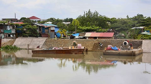 WORKERS from DPWH Bulacan 1st District contractors are busy laying concrete along the riverbank protection structure at Barangay Santa Cruz in Guiguinto, Bulacan.