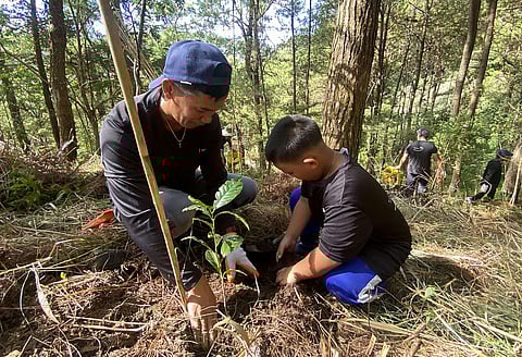 RESOURCE conservation A Hedcor team member and his son participate in a tree-planting activity at the La Trinidad Hydroelectric Plant in Alapang, Benguet, which draws its power from the Balili River.