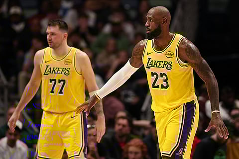 LEBRON James (right) and Luka Doncic join hands as the Los Angeles Lakers get past the New Orleans Pelicans, 111-103, in the NBA.