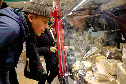 People shop for cheese in a grocery store in the Manhattan borough of New York City on December 13, 2025.