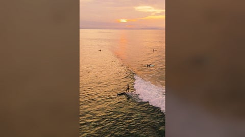 SURFERS paddle out at Tangbo Surf Spot, just steps from Ora Kafé, chasing clean breaks from sunrise to sunset.