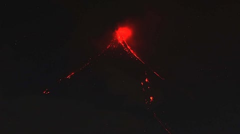 PYROCLASTIC density currents are seen flowing down the slopes of Mayon Volcano in Legazpi City, Albay on Sunday night.