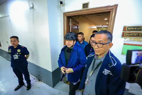 Dismissed Bulacan district engineer Henry Alcantara is being escorted by authorities out of the Senate building, where he has been detained since September last year after being cited in contempt in relation to the flood control scam. He has been admitted as a state witness.