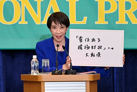 Liberal Democratic Party President and Japan's Prime Minister Sanae Takaichi holds up her party's election predictions during the Panel Discussion by the Leaders of 7 Parties at the Japan National Press Club (JNPC) in Tokyo on January 26, 2026.