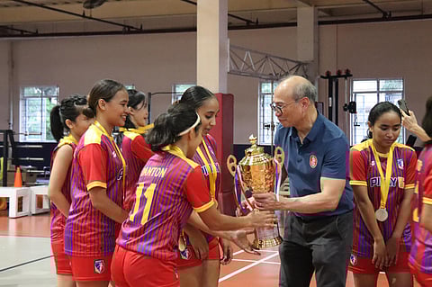 DANIEL Moran, chairman and president of the Henry V. Moran Foundation, hands the trophy to Pinay5 after winning the women’s division of the High5 Futsal League National Invitational Championship over the weekend.
