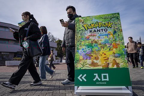 People walk past signage of 'PokePark Kanto' outside the Yomiuri Land amusement park in Inagi, Tokyo prefecture on 6 February 2026.
The first permanent Pokemon theme park opened in Tokyo on 5 February 2026, featuring cute rides and a woodland area where visitors can try and "catch 'em all".