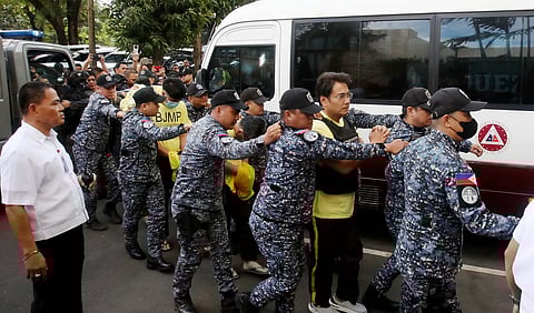 BUREAU of Jail Management and Penology personnel tightly guard former Senator Ramon ‘Bong’ Revilla Jr. and 15 co-accused as they arrive at the Sandiganbayan in Quezon City on Monday for a hearing on their malversation and graft cases over the alleged anomalous flood control projects.