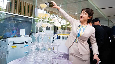 EPSON Philippines president and director Masako Kusama pours champagne on the glass tower before the ceremonial toast at the Epson Cebu office launch.