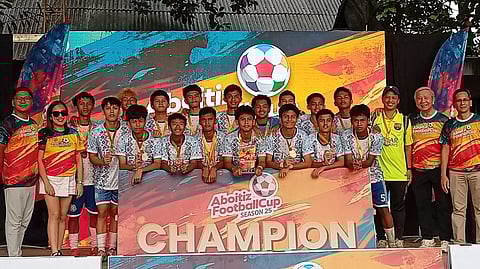 MEMBERS of the RMC Bulldogs celebrate with Davao South Regional Football Association president Ernie Ortonio Jr., Impact Load’s Welfredo Dallumpines, organizer Liza Kriztel Dureza-Valencia and tournament director Arman Valencia after ruling the U18 division of the Aboitiz Football Club in Davao City over the weekend.
