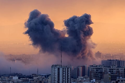 A plume of smoke rises after strikes on Iran's captial, Tehran, on 3 March 2026.