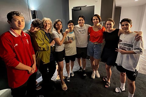 (FILES) An undated photo released by Australia's Department of Home Affairs on March 11, 2026 shows Iranian women's football team captain Zahra Ghanbari (4th R) posing with other members of the Iranian women's football team to claim asylum in Australia Mohaddeseh Zolfi (L), support member Zahra Soltan Meshkeh Kar (3rd L), Fatemeh Pasandideh (2nd L), Atefeh Ramezanizadeh (4th L), Mona Hamoudi (C), and Zahra Sarbali (R), along with two other local officials (2nd and 3rd R) in Sydney. The captain of the Iranian women's football team, which played in the Asian Cup in Australia, has withdrawn her bid for asylum, Iran state media said on March 15, 2026, making her the fifth member of the delegation to change her mind.