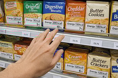 A SHOPPER checks nutrition labels before choosing, highlighting the importance of food literacy and informed decisions, as emphasized by the Philippine Association of Nutrition.