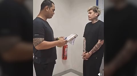 FORMER PBA player Mark Cardona (right) is being questioned by an officer following his arrest last 28 March for allegedly kissing a college student against her will.