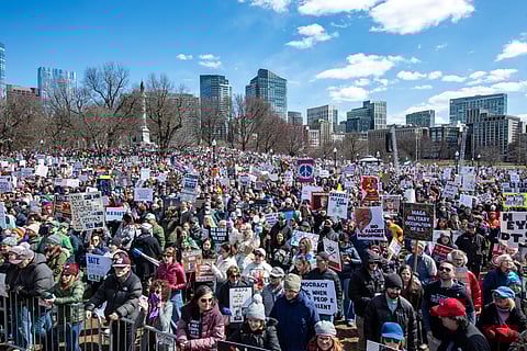 PEOPLE hold signs and wave flags as they gather at Boston Common during the ‘No Kings’ national day of protest in Boston, Massachusetts, on 28 March 2026.