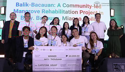 CHEd University of the Philippines Visayas students pose with UP officials and a mock check of their capstone grant for their Balik-Bacauan: A Community-Led Mangrove Rehabilitation Project.