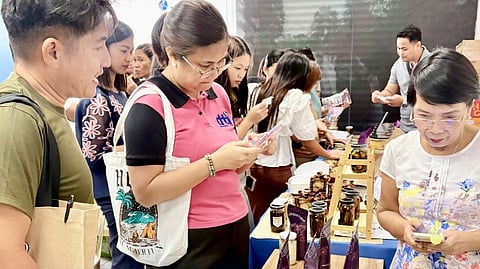 A DEPARTMENT of Trade and Industry representative checks products made from purple yam or ube during a recent product exposition. From New York coffee shops to Sydney bakeries, ube is taking the world by storm. Exports are booming.