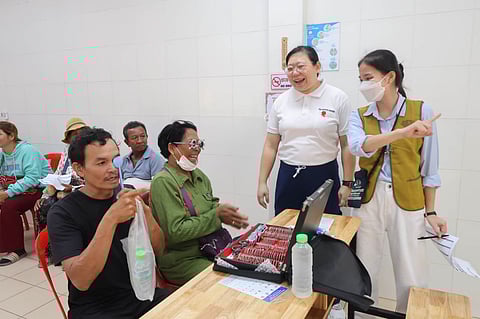 CAMBODIAN patients (left) get their eye grades measured by Tzu Chi volunteer and optometrist Dr. Adriene Lim (2nd from left).