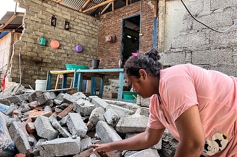 A RESIDENT clears debris from a damaged wall of her home after a shallow 4.9 magnitude earthquake in Adonara, East Nusa Tenggara on 9 April 2026, damaging dozens of homes and injuring multiple people, an official said.