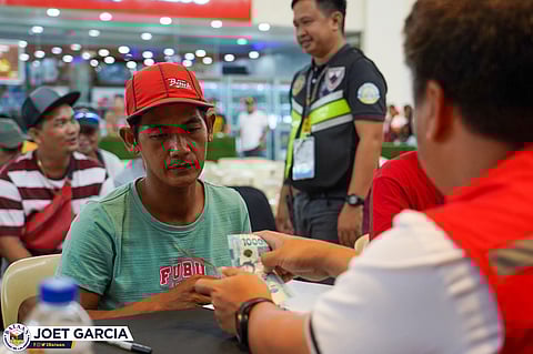 A tricycle driver receives his cash assistance from a DSWD personnel in Balanga City, Bataan on April 8, 2026.