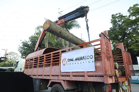 A MERALCO truck unloads wooden posts at the Manila Boystown donated by OMF.