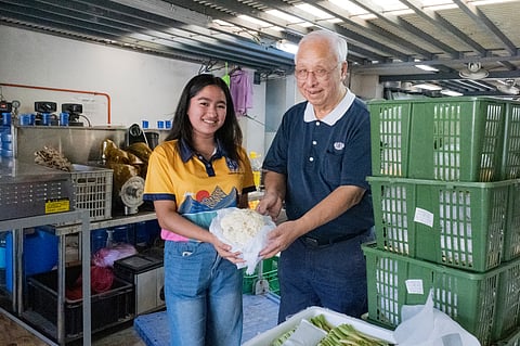 SOCIAL worker Rosalyn Endriga of the Missionaries of Charity Brothers in Novaliches, Quezon City, and Tzu Chi volunteer James Cheng pose for a photo with the donated vegetables received for their charity.