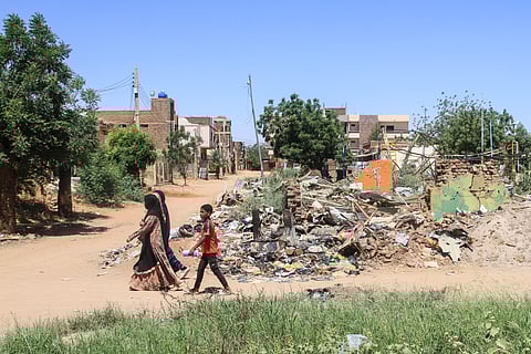 People walk past the rubble of a building in the capital Khartoum on 15 April 2026, on the third anniversary of the start of the war between the army and its paramilitary foes. On the third anniversary of the start of the grinding conflict on 15 April, donors will gather in Berlin for an international conference aimed at reviving faltering peace talks and mobilising aid for one of the world's worst humanitarian crises.
