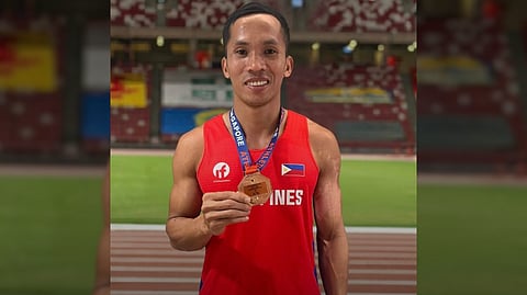 JANREY Ubas proudly shows off the long jump bronze medal that he picked up in the Singapore Open Track and Field Championships.