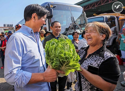 President Ferdinand Marcos Jr. talks to a vegetable farmer after buying their produce in Benguet, Mt. Province on Friday.
