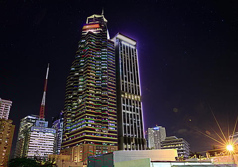 A HIGH-RISE office tower lights up the Makati skyline at night.