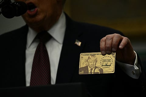 US President Donald Trump holds up a "Trump Gold Card" as he makes an announcement from the Roosevelt Room of the White House in Washington, DC on 19 December 2025.
