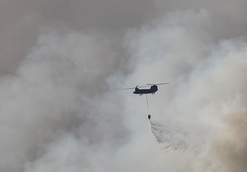 A Japan Self Defense Force helicopter drops water on the head of the fire near the town of Otsuchi in Iwate Prefecture on April 25, 2026. Hundreds of firefighters were battling wildfires in the forests of northern Japan on April 25, as authorities urged more than 3,200 people to evacuate from their homes, government officials said.