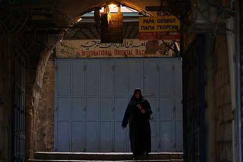A nun carrying candles, walks towards the Church of the Holy Sepulchre in the old city of Jerusalem on 3 May 2026.