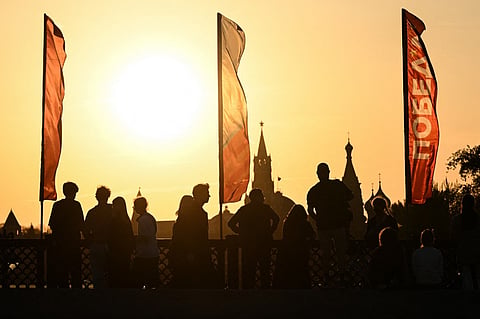 PEDESTRIANS on Bolshoy Ustyinsky Bridge in central Moscow, decorated with flags, wait for Russian servicemen ahead of the Victory Day military parade rehearsal.