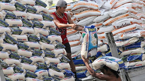 Imported rice are being unloaded by workers along Dapitan Street in Manila.
